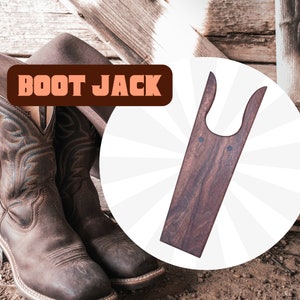 May include: A wooden boot jack with a dark brown finish. The boot jack is shaped like a boot with a U-shaped opening at the top. The text "BOOT JACK" is displayed in a red banner.