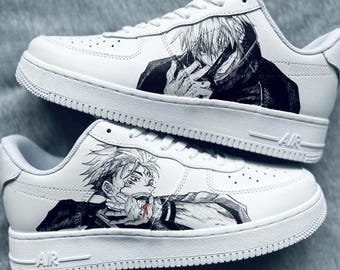 May include: White sneakers with black and white anime-style illustrations. The shoes feature detailed artwork of characters on the sides. The soles and laces are white, and the design is set against a gray background.