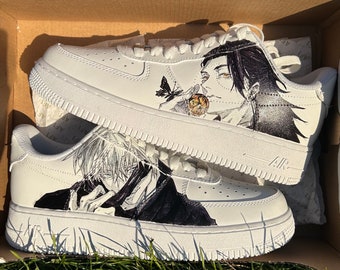 May include: A pair of white sneakers with black and white anime character illustrations. The sneakers have the word "Air" printed on the side.