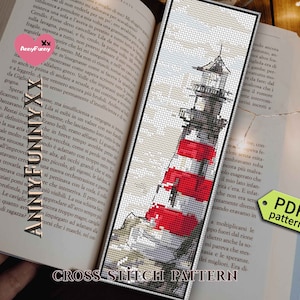 Könnte beinhalten: Kreuzstich-Lesezeichen mit einem Leuchtturm mit roten und weißen Streifen vor grauem Himmel. Das Lesezeichen befindet sich in einem offenen Buch. Der Text "CROSS STITCH PATTERN" steht unten.