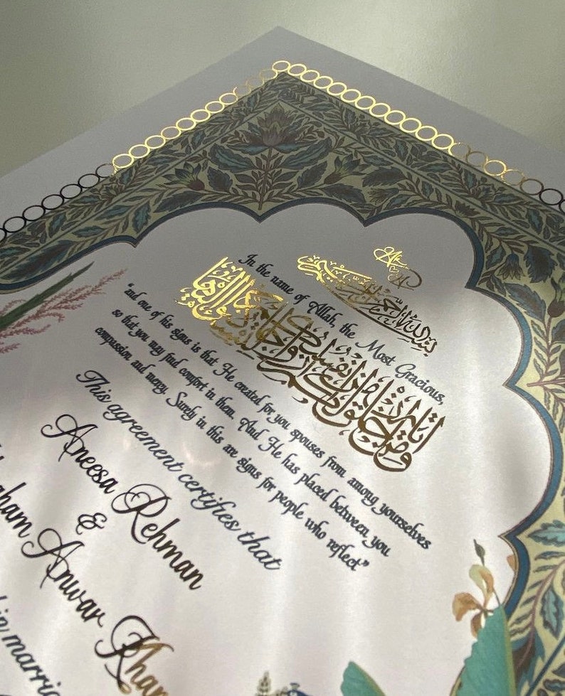 May include: A white wedding certificate with gold calligraphy and floral designs. The text reads "In the name of Allah, the Most Gracious...This agreement certifies that Aneesa Rehman & Ibrahim Anwar Khan marriage"