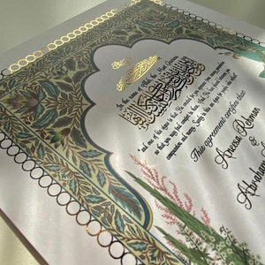 May include: A white background with gold and green floral designs. The text "In the name of Allah, the Most Gracious" is written in Arabic calligraphy. The text "This agreement certifies that Aneesa Rehmar & Abraham" is written in cursive.