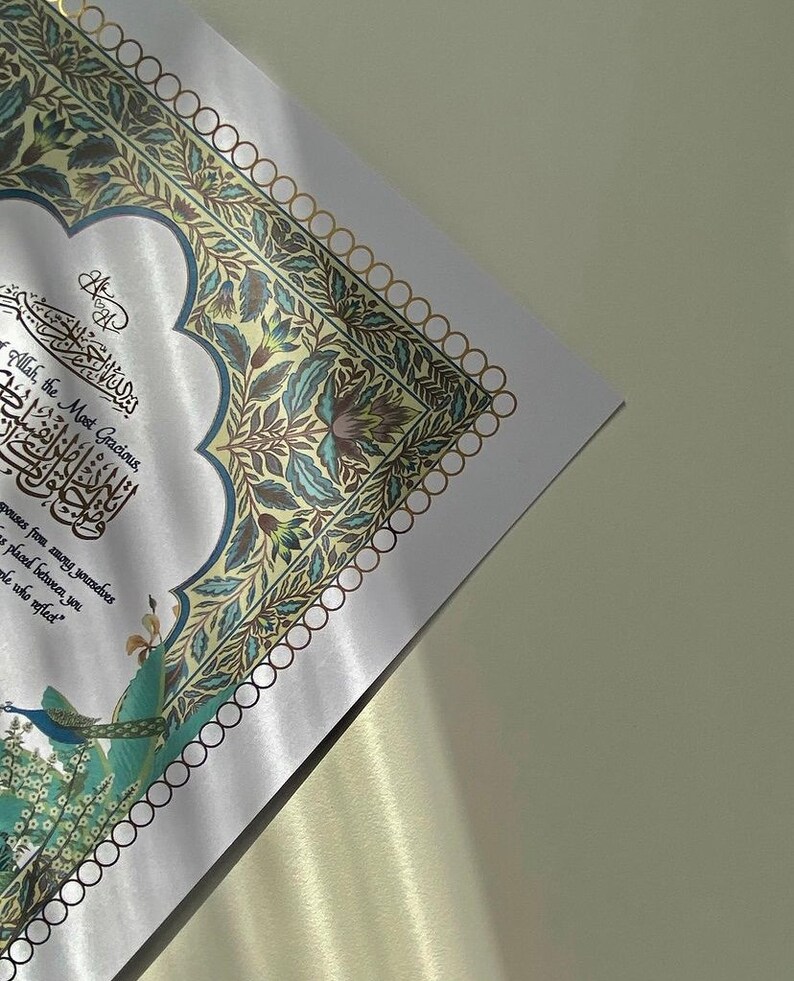 May include: A white background with a decorative border of gold and blue floral designs. The text "Allah, the Most Gracious" is written in Arabic calligraphy in the centre of the image.