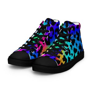 May include: High-top trainers with a colourful leopard print pattern. The shoes have black toe caps, black laces, and a black sole. The leopard print design transitions through shades of blue, pink, and yellow.