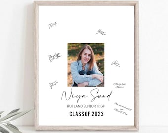 May include: A framed print featuring a photograph of a young woman, surrounded by handwritten signatures. The print includes the text "Niya Sund," "Rutland Senior High," and "Class of 2023." The frame is a light wood color.
