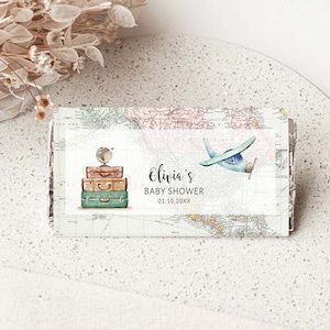 Puede incluir: Una invitación a un baby shower con temática de viaje. La invitación presenta un avión azul, una pila de maletas vintage y un globo terráqueo. El texto de la invitación dice "Baby Shower de Olivia 01.10.20XX".