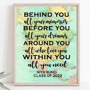 May include: A framed print with a vintage map background and a motivational quote in black text: "Behind you all your memories, before you all your dreams, around you all who love you, within you all you need." The bottom of the print has the name "Niya Sund" and "Class of 2022" in black text.