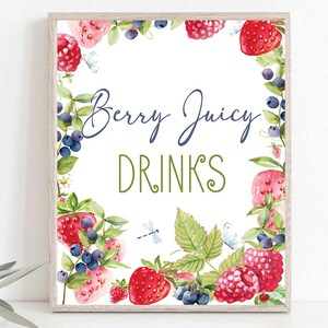 May include: A printable sign with a white background and a border of watercolour illustrations of berries, leaves, and butterflies. The text "Berry Juicy Drinks" is written in blue and green lettering.