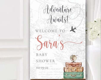 Puede incluir: Un cartel de bienvenida blanco con un fondo de mapa del mundo vintage. El texto "Adventure Awaits!" está escrito en letra cursiva. El texto "Welcome to Sara's Baby Shower" está escrito en negro. La fecha "02-19-22" está escrita en negro. Hay maletas y un globo terráqueo encima de las maletas.