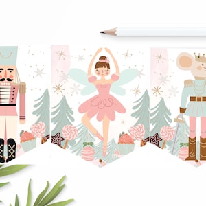 Pode incluir: Uma faixa festiva com um Quebra-Nozes rosa e azul, uma bailarina com asas e um rei rato. Os personagens estão rodeados por bengalas de doces, cupcakes e flocos de neve sobre um fundo branco.