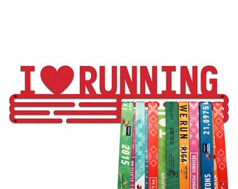 May include: Red metal medal holder with the words "I love running" and a red heart. The holder has five rows of hooks for hanging medals. There are several colorful race bibs hanging on the hooks.
