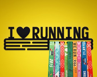 May include: Black metal medal holder with the words "I ♥ RUNNING" and a design of parallel lines. The holder has several colorful running race medals hanging from it.