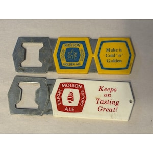 May include: Two Molson beer bottle openers. One has a yellow and blue design with the text "Molson Golden Ale" and "Make it Cold 'n' Golden". The other is white with "Molson Export Ale" and "Keeps on Tasting Great!"