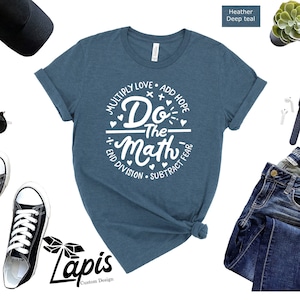 May include: A heather deep teal t-shirt with a white circle graphic that says "Do the Math" with the words "Multiply Love, Add Hope, End Division, Subtract Fear" around the circle.