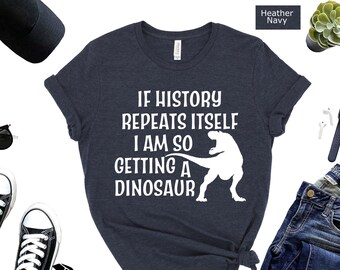 May include: A heather navy blue t-shirt with a white graphic that says "If history repeats itself I am so getting a dinosaur" and a white dinosaur illustration.
