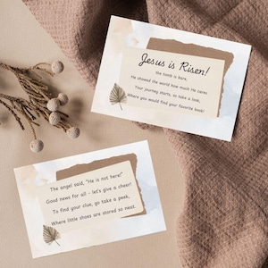 May include: Two cards with a light brown background and white text. The top card says "Jesus is Risen! The tomb is bare, He showed the world how much He cares. Your journey starts, so take a look, Where you would find your favorite book!" The bottom card says "The angel said, "He is not here!" Good news for all - let's give a cheer! To find your clue, go take a peek, Where little shoes are stored so neat."
