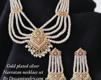 Op de afbeelding: Vergulde zilveren Navratan kettingset met witte parels en gekleurde stenen. Door Deccanjewelry.com