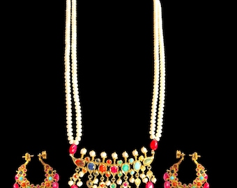 Op de afbeelding: Een gouden ketting met een veelkleurige edelsteen hanger en een parelstreng. De ketting wordt geleverd met bijpassende oorbellen met een vergelijkbaar ontwerp.
