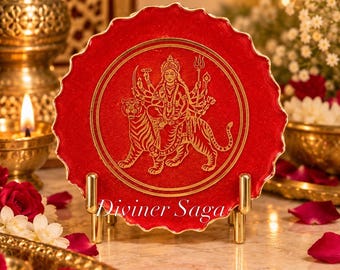 May include: A circular red resin decorative plate with a scalloped edge, featuring a gold-colored embossed illustration of a multi-armed deity riding a tiger. The plate is displayed on a gold metal stand and includes the text Diviner Saga.