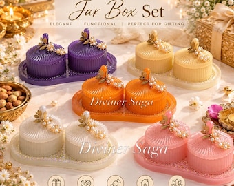 May include: A set of four double jar box sets by Diviner Saga in purple, yellow, orange, white, and pink. Each set features two ribbed circular jars with lids topped with gold leaf and pearl accents, resting on a matching oval tray.