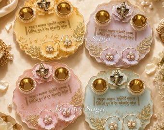 May include: Four decorative resin trays in pastel colors: yellow, lavender, pink, and blue. Each tray features a gold-colored elephant figurine, two gold-colored bowls, floral embellishments, and text in a foreign language. The trays are adorned with pearls.