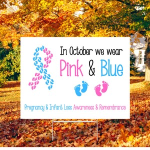 Pode incluir: Uma placa de jardim branca com texto e gr&aacute;ficos. A placa diz "Em outubro vestimos rosa e azul" com uma fita e pegadas em rosa e azul. Para a conscientiza&ccedil;&atilde;o e lembran&ccedil;a da perda gestacional e infantil.
