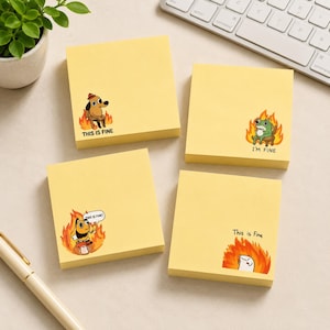 Puede incluir: Cuatro notas adhesivas amarillas cuadradas con ilustraciones de dibujos animados de personajes sentados entre llamas. Una muestra un perro con el texto THIS IS FINE, una rana con I'M FINE, una abeja con THIS IS FINE y una criatura blanca con This is Fine.