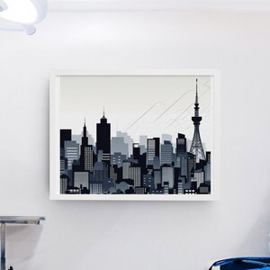 以下が含まれることがあります： 黒とグレーの都市景観のシルエットが描かれた、額入りのアートプリント。さまざまな建物と特徴的なタワーが描かれたスカイラインです。医療現場の白い壁に飾られています。
