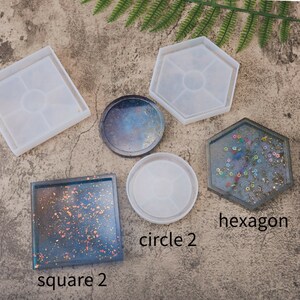 May include: Five silicone molds for resin crafts. The molds are in the shapes of a square, hexagon, and two circles. One circle has a galaxy design. The text "hexagon", "circle 2", and "square 2" is written below the molds.