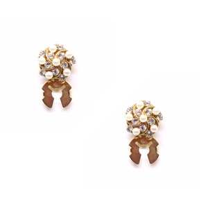 Peut inclure: Une paire de boucles d'oreilles dor&eacute;es avec un motif en spirale orn&eacute; de perles blanches et de strass transparents. Les boucles d'oreilles ont une fermeture &agrave; clip.