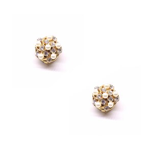 Peut inclure: Une paire de boucles d'oreilles en or avec un motif en spirale et des accents de perles blanches.