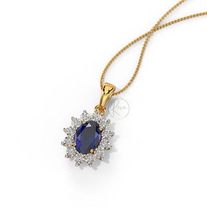 May include: A gold pendant necklace featuring a large oval blue sapphire surrounded by smaller diamonds. The necklace is on a delicate gold chain.