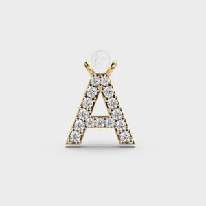 May include: A gold pendant charm in the shape of the letter A, with small clear stones set around the edges.