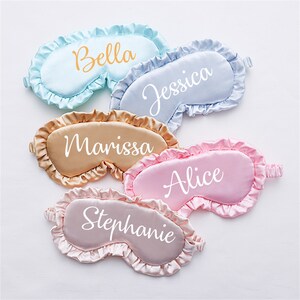 May include: Five satin sleep masks with ruffled edges, each with a different name embroidered in white: Bella, Jessica, Marissa, Alice, and Stephanie.