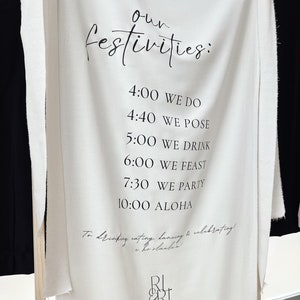 Könnte beinhalten: Ein weißes Stoffbanner mit schwarzem Text, der "our festivities:" lautet und einen Zeitplan mit Veranstaltungen auflistet. Der Text beinhaltet "We Do", "We Pose", "We Drink", "We Feast", "We Party" und "Aloha". Das Banner enthält auch den Text "To drinking, eating, dancing & celebrating!" und das Logo "RL ERL".