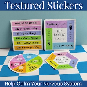 May include: Four textured stickers with grounding and breathing exercises. Two are square, one is circular, and one is hexagonal. They feature colorful sections with text including "Colors of the Rainbow," "Box Breathing," "4-7-8 Breathing," and "5 Senses."