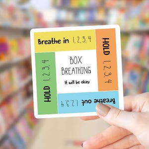May include: A square sticker featuring a box breathing guide with four colored sections. The text reads: Breathe in 1, 2, 3, 4, HOLD 1, 2, 3, 4, Breathe out 1, 2, 3, 4, and HOLD 1, 2, 3, 4. The center white square displays the text BOX BREATHING It will be okay.