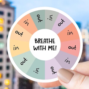 May include: A circular sticker featuring a color wheel with alternating pastel segments in shades of peach, sage green, yellow, and lavender. The center white circle displays the text BREATHE WITH ME! while each segment contains the word in or out.