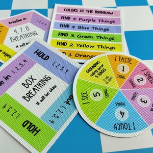 May include: Three square and circular cards featuring colorful educational graphics. One card displays 4-7-8 breathing instructions, another outlines box breathing steps, and the third is a circular chart for grounding using five senses.