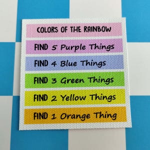 May include: A square white card featuring horizontal colored bars with black text. The text reads: COLORS OF THE RAINBOW, FIND 5 Purple Things, FIND 4 Blue Things, FIND 3 Green Things, FIND 2 Yellow Things, and FIND 1 Orange Thing.