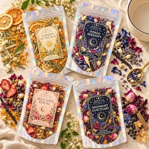 May include: Four iridescent pouches of botanical simmer pot blends labeled Garden of the Sun, Indigo Serenity, Self Love Ritual, and Midnight Sanctuary. Each pouch contains dried flowers, fruit slices, and spices, surrounded by loose ingredients.