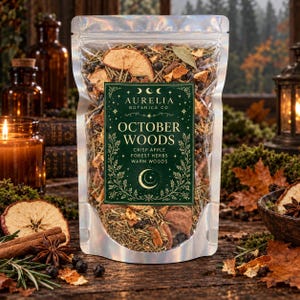 May include: A clear resealable pouch filled with a dried botanical blend of apple slices, herbs, and berries. The label features the text Aurelia Botanica Co. October Woods, Crisp Apple, Forest Herbs, Warm Woods, and a crescent moon graphic.