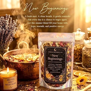 May include: A clear pouch of New Beginnings aromatic simmer blend containing dried lemon, apple, rose petals, chamomile, lemongrass, blue cornflower, calendula, and lavender, with a label listing ingredients and palmarosa essential oil.