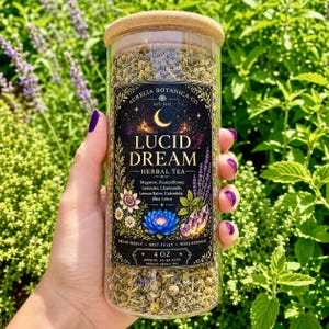 Peut inclure: Un bocal en verre transparent avec un couvercle en bambou rempli de tisane s&eacute;ch&eacute;e. L'&eacute;tiquette noire pr&eacute;sente un croissant de lune, un lotus bleu, des cristaux et le texte : Aurelia Botanica Co. Lucid Dream Herbal Tea, Mugwort, Passionflower, Lavender, Chamomile, Lemon Balm, Calendula, Blue Lotus, 4 oz, env. 40-60 tasses.