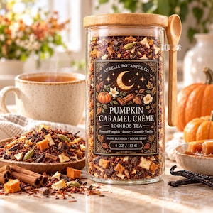 Peut inclure: Un bocal en verre transparent rempli de thé rooibos en vrac, avec un couvercle en bois et une petite cuillère en bois. L'étiquette indique Aurelia Botanica Co. Pumpkin Caramel Crème, 4 oz / 113 g. Le mélange contient des morceaux de citrouille.