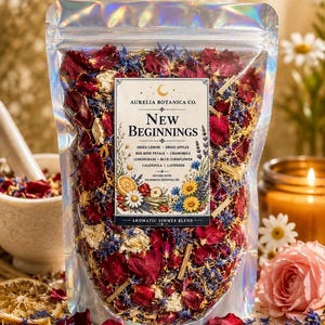 May include: A holographic pouch filled with a dried botanical blend featuring red rose petals, blue cornflowers, yellow calendula, chamomile, dried lemon, and apple slices. The label reads Aurelia Botanica Co. New Beginnings Aromatic Simmer Blend.