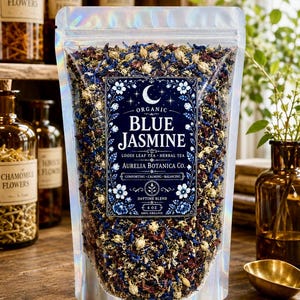 May include: A holographic pouch of Aurelia Botanica Co. Blue Jasmine loose leaf herbal tea. The label features a crescent moon, floral borders, and the text: Organic Blue Jasmine, Loose Leaf Tea, Herbal Tea, Comforting, Calming, Balancing, Daytime Blend, 4 oz, 100% Organic.