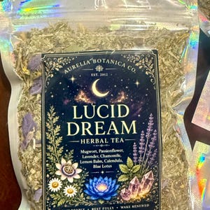 Peut inclure: Un sachet transparent &agrave; bords holographiques contenant une tisane en vrac. L'&eacute;tiquette indique Aurelia Botanica Co. Lucid Dream Herbal Tea, avec des ingr&eacute;dients comme l'armoise, la passiflore, la lavande, la camomille, la m&eacute;lisse, le souci et le lotus bleu. Poids 57 grammes.