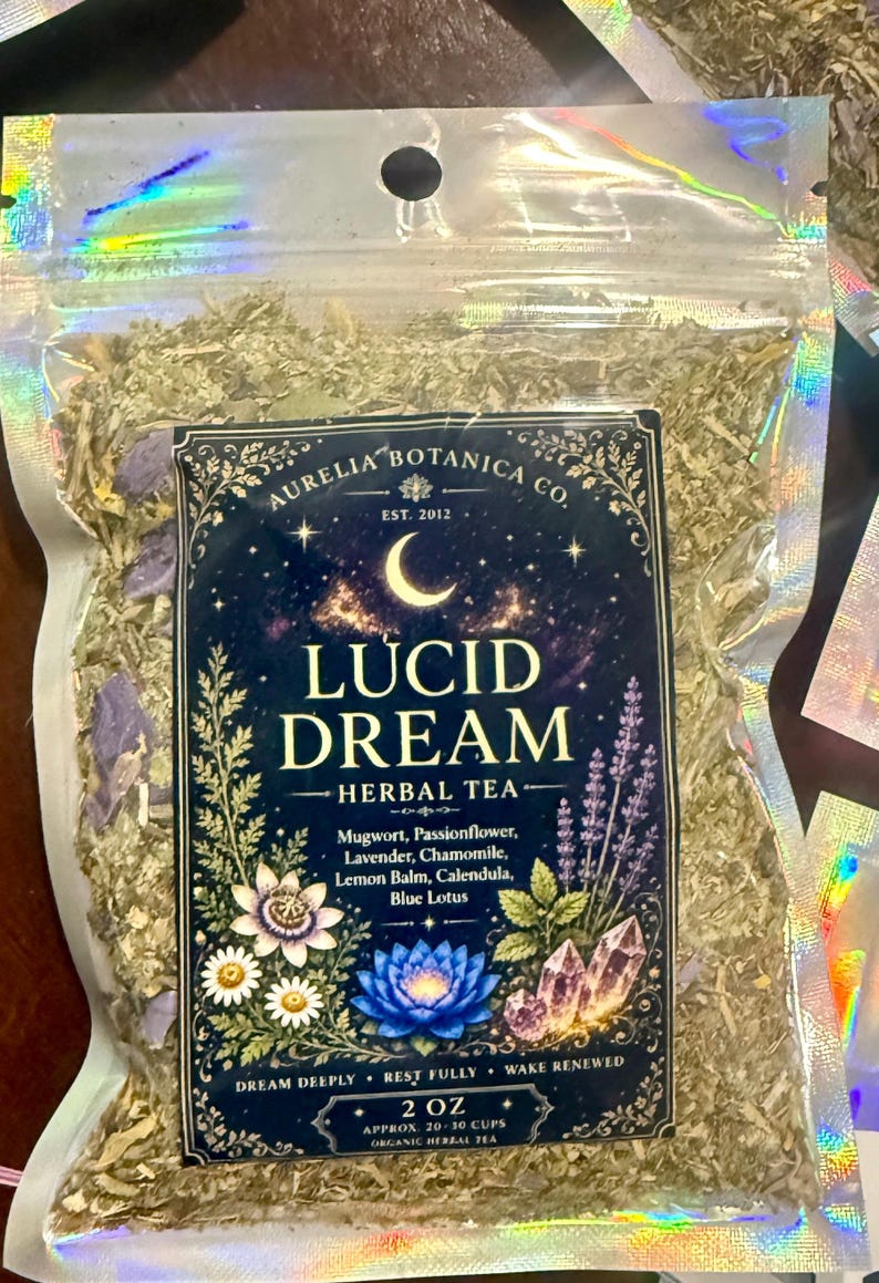 Peut inclure: Un sachet transparent &agrave; bords holographiques contenant une tisane en vrac. L'&eacute;tiquette indique Aurelia Botanica Co. Lucid Dream Herbal Tea, avec des ingr&eacute;dients comme l'armoise, la passiflore, la lavande, la camomille, la m&eacute;lisse, le souci et le lotus bleu. Poids 57 grammes.