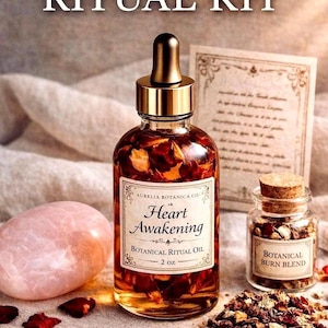 May include: A Heart Awakening Ritual Kit featuring a glass bottle of botanical ritual oil, a small jar of botanical burn blend, a rose quartz stone, and a ritual card. The oil bottle is 2 oz. and has a gold dropper.